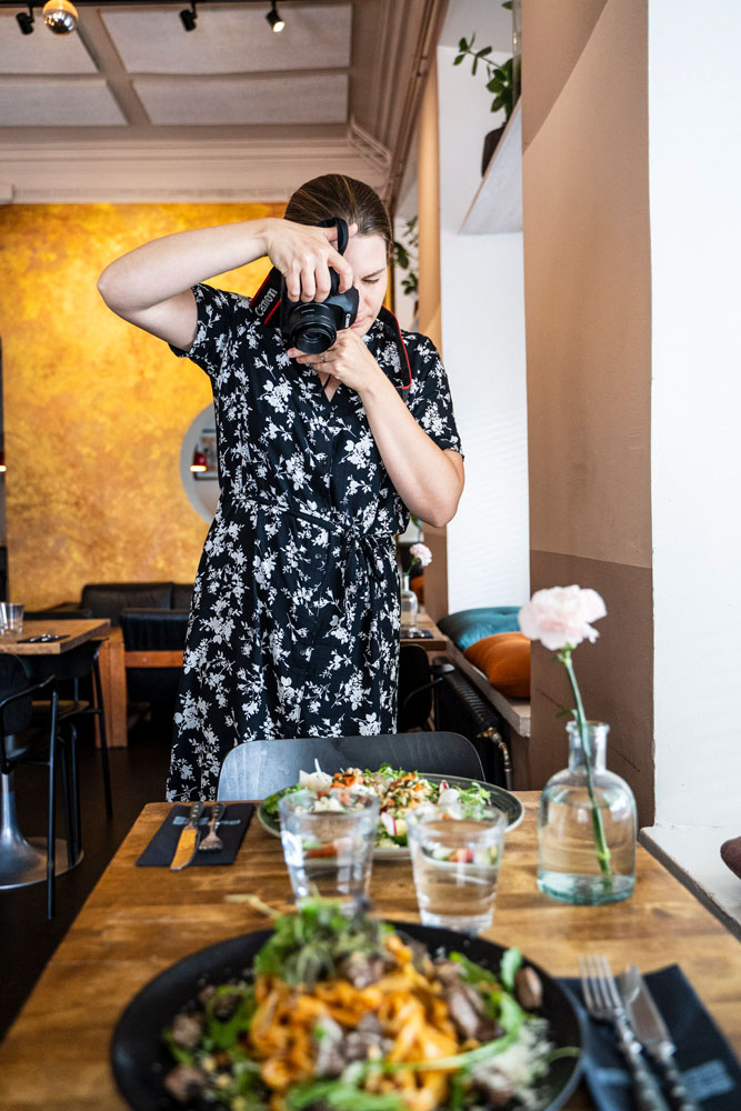 Satu taking a picture of a dish in a beautifully decorated table