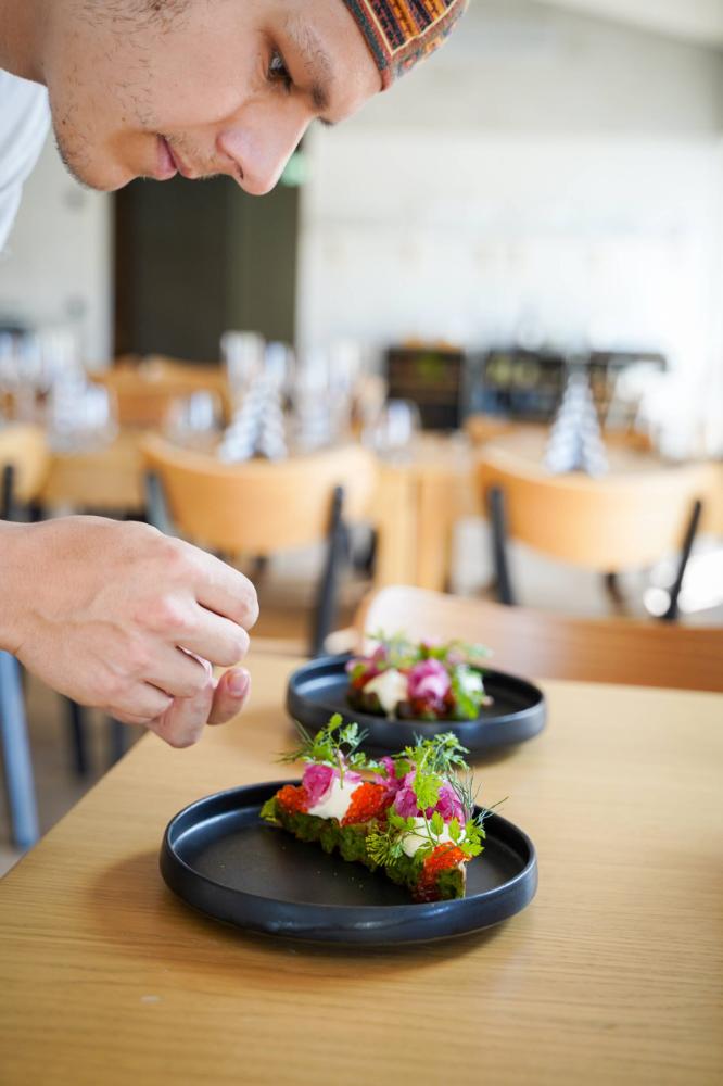 A chef preparing a plate of food in a restaurant.